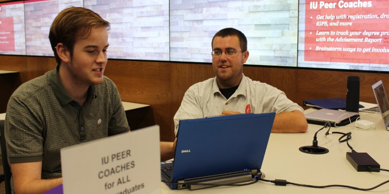 Students working on a laptop at the IU Peer Coaches table in Wells Library.